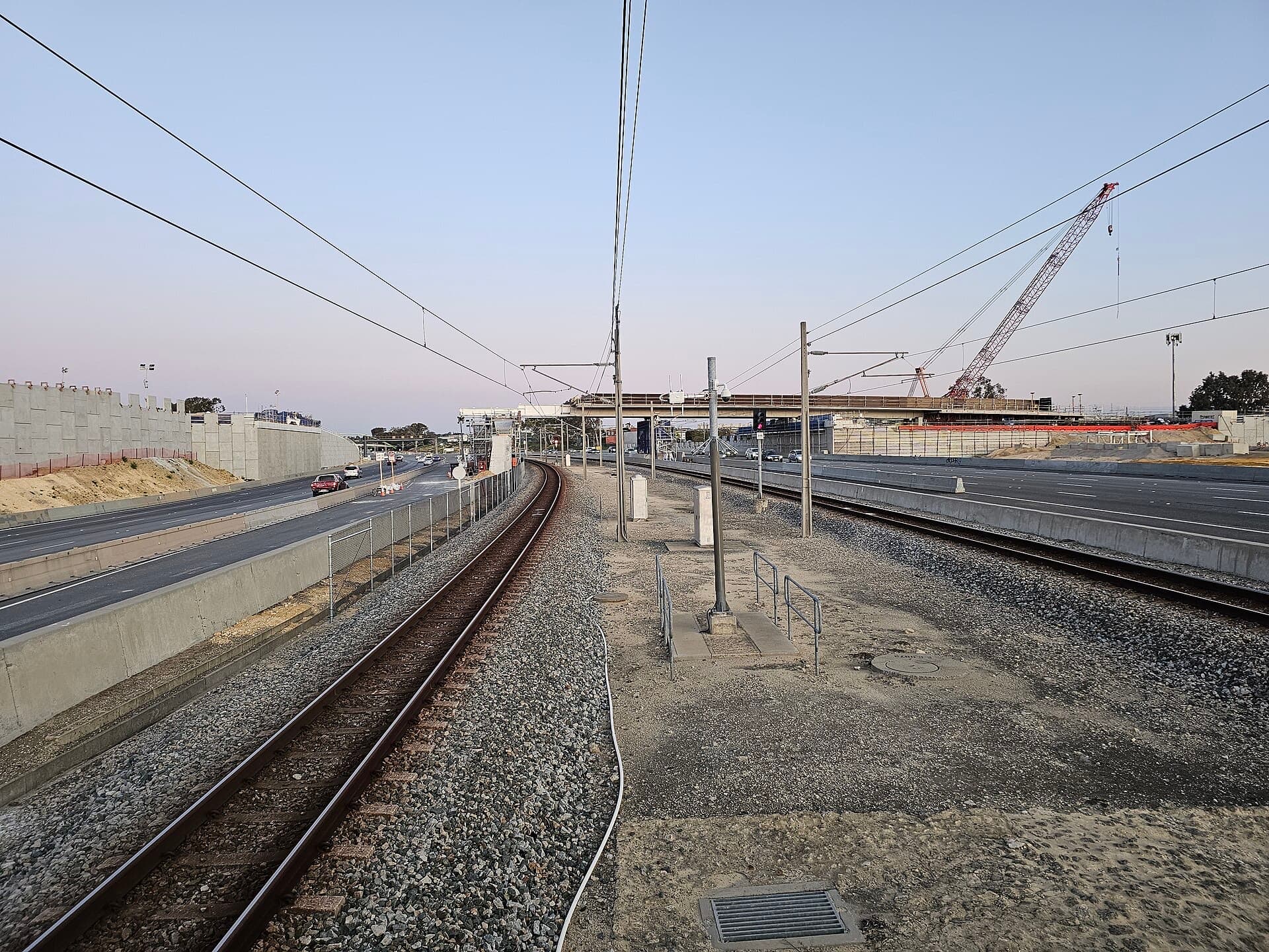 Freeway widening and rail works beside the Stephenson Avenue bridge in Perth, Western Australia, with a crawler crane on site.